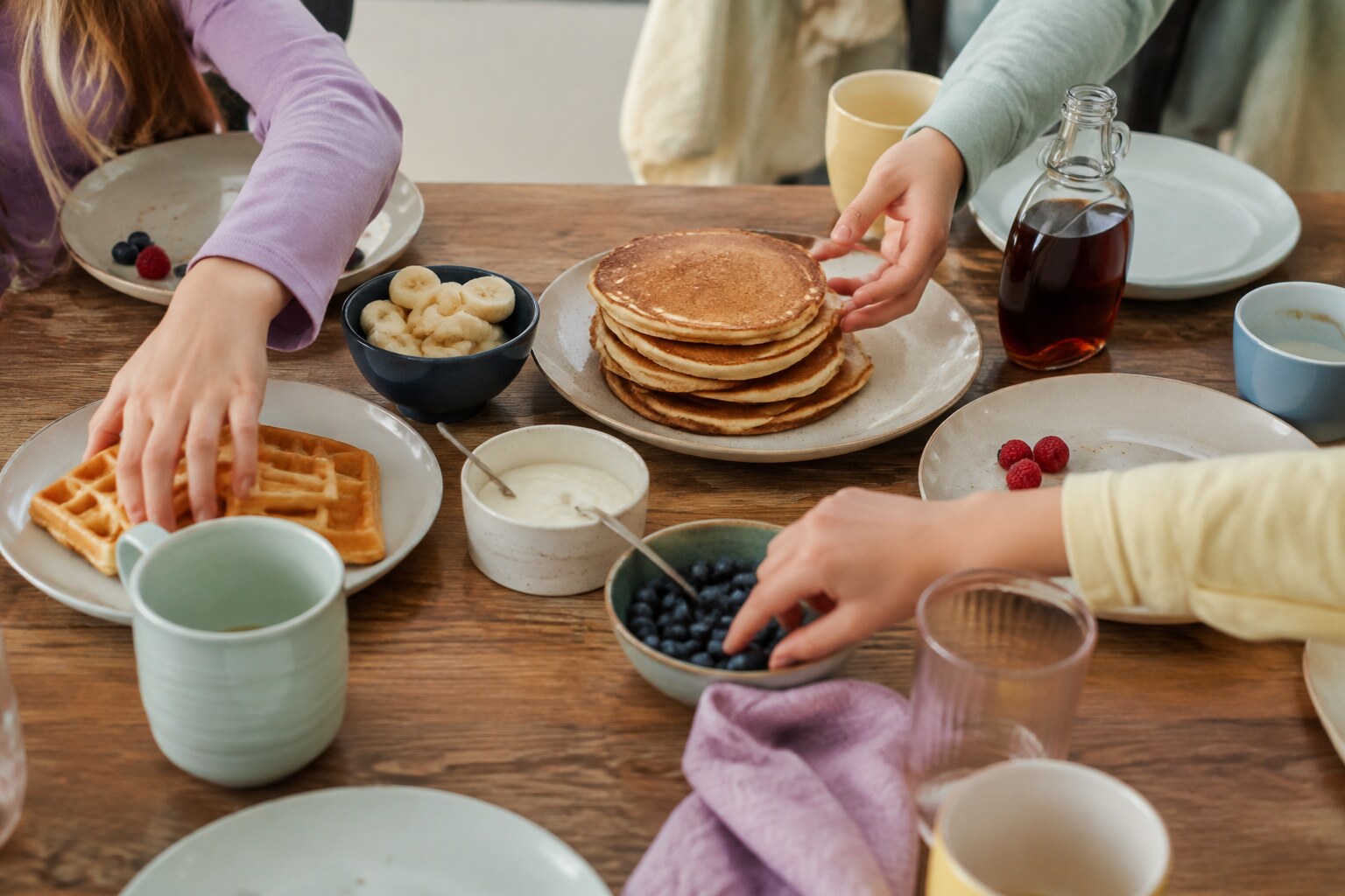 Children serving themselves pancakes, waffles and fruit at an easy morning-after sleepover breakfast