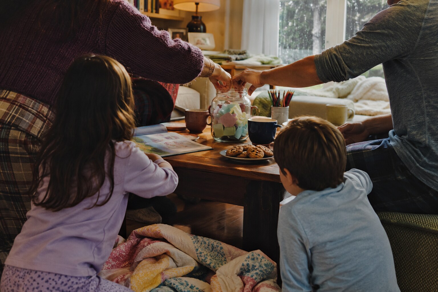 A family choosing an activity from a jar together on a cozy rainy afternoon